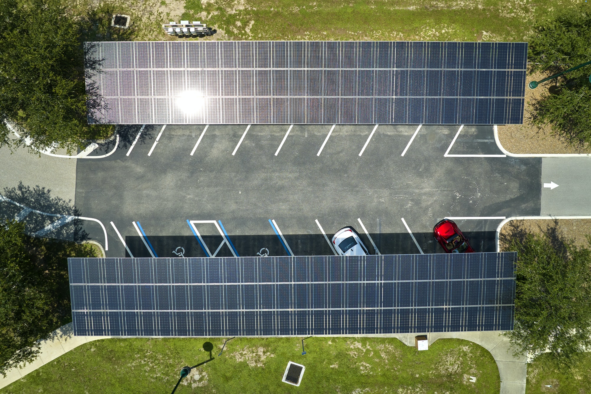 Aerial view of solar panels installed as shade roof over parking lot for parked cars