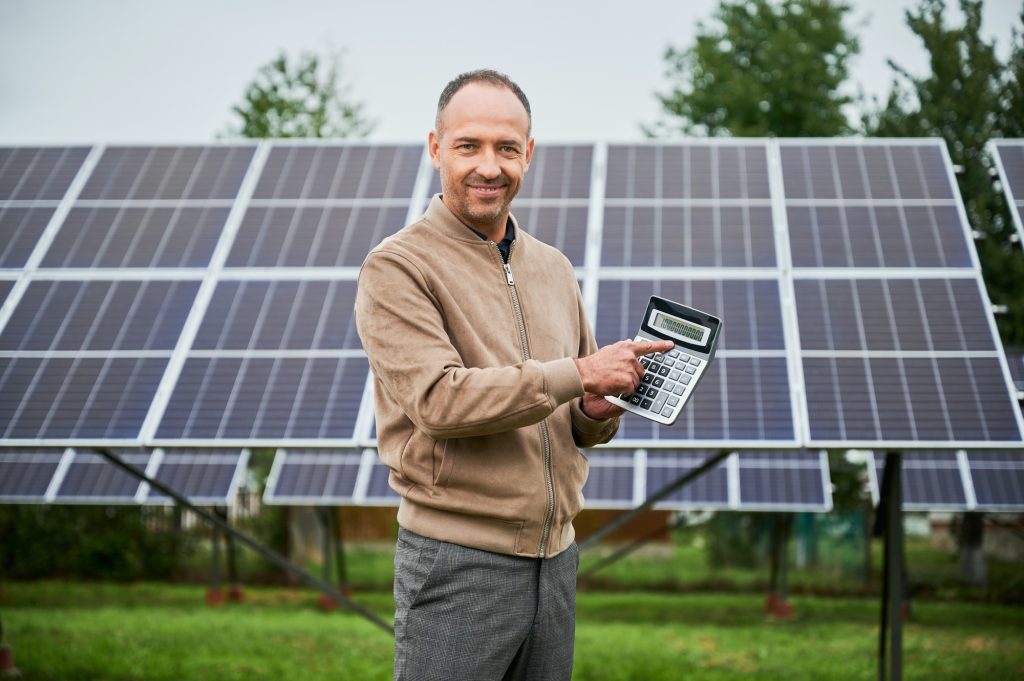 Happy man showing his future profit from investing in solar panels.